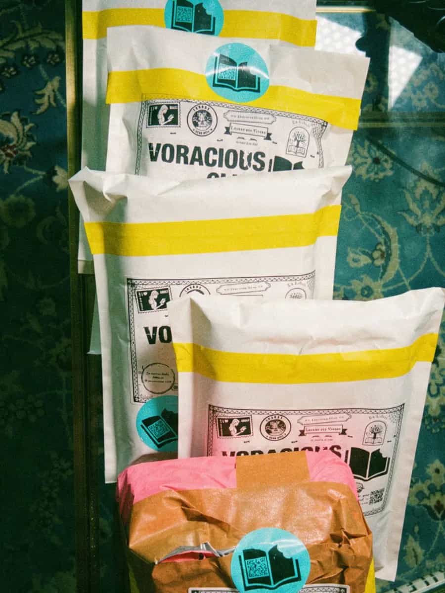 White padded mailers sealed with yellow tape, each carrying a Voracious Club label and a round sticker